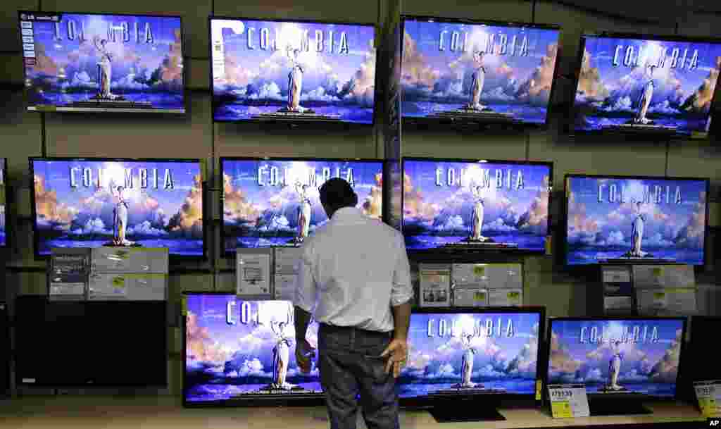 A shopper looks at televisions at a Best Buy store in Franklin, Tennessee, November 23, 2012.