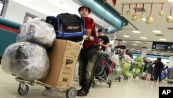 FILE - Travelers wait to check in for travel at Miami International Airport. The U.S. and Cuba reportedly are planning to resume regularly scheduled commercial flights.