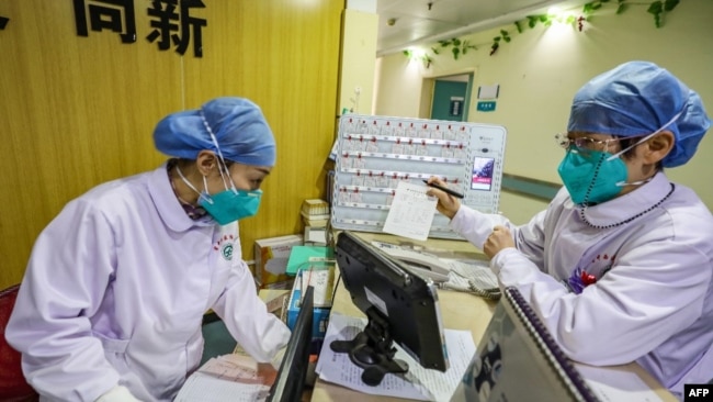 中国武汉一所医院的医务人员戴着口罩在工作。（2020年1月30日）