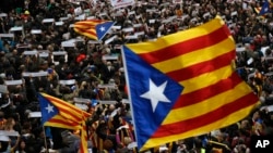 FILE - Thousands of people rally outside the regional presidential palace in Sant Jaume Square during a general strike in Barcelona, Spain, Nov. 8, 2017. 