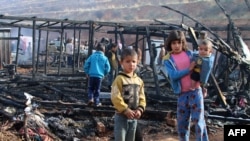 FILE - Syrian refugees check the damage following a fire that ripped through their refugee camp in the village of Yammouneh in Lebanon's eastern Bekaa Valley on Dec. 3, 2018.