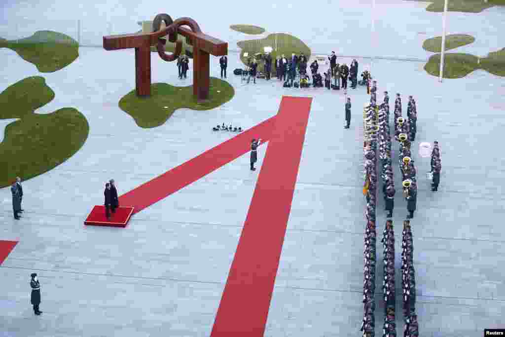 German Chancellor Angela Merkel and Greek Prime Minister Alexis Tsipras review an honor guard during a welcoming ceremony at the Chancellery in Berlin.