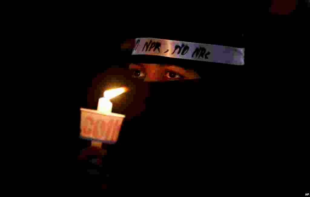 An Indian Muslim woman holds a candle during a protest against a new citizenship law that opponents say threatens India&#39;s secular identity in Bangalore, India.