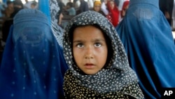 Afghan refugees wait for their documents to go back to Afghanistan at the UNHCR's Repatriation Center in Peshawar, Pakistan on June 23, 2016. 