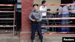 FILE - A police officer stands guard at Insein court in Yangon, Myanmar, Feb. 15, 2019.