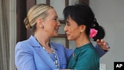 Burmese democracy leader Aung San Suu Kyi (R) greets visiting US Secretary of State Hillary Clinton following their meeting at Suu Kyi's residence in Rangoon, December 2, 2011.