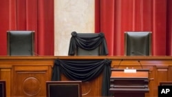 FILE - Supreme Court Justice Antonin Scalia’s courtroom chair is draped in black to mark his death as part of a tradition that dates to the 19th century at the Supreme Court in Washington, Feb. 16, 2016. 