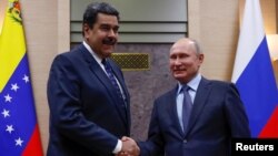 El presidente ruso Vladimir Putin le da la mano a su homólogo venezolano Nicolás Maduro, durante una reunión en la residencia estatal de Novo-Ogaryovo fuera de Moscú, Rusia. Foto de archivo.