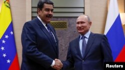 FILE PHOTO: Russian President Vladimir Putin, right, shakes hands with his Venezuelan counterpart Nicolas Maduro during a meeting at the Novo-Ogaryovo state residence outside Moscow, Russia Dec. 5, 2018. 