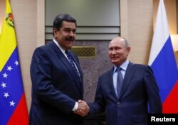 FILE PHOTO: Russian President Vladimir Putin, right, shakes hands with his Venezuelan counterpart Nicolas Maduro during a meeting at the Novo-Ogaryovo state residence outside Moscow, Russia Dec. 5, 2018.