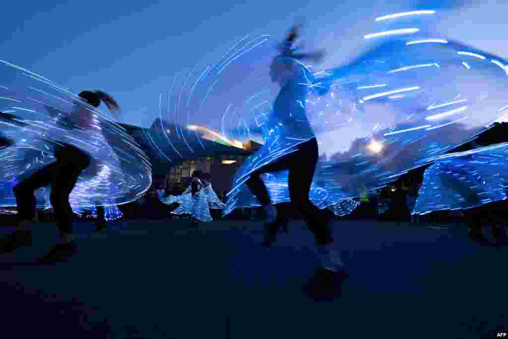 Women dance wearing lights during the lantern festival, part of the Chinese New Year celebrations, on the waterfront in Wellington, New Zealand.