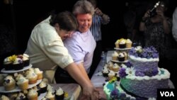 Pasangan lesbian Cheryle Rudd (kiri) dan Kitty Lambert memotong kue pernikahan mereka dalam upacara pernikahan di Niagara Falls, negara bagian New York (24/7).