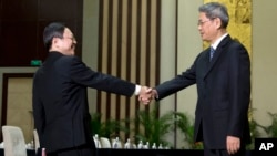 Wang Yu-chi, left, head of Taiwan's Mainland Affairs Council, shakes hands with Zhang Zhijun, director of China's Taiwan Affairs Office, Nanjing, Feb. 11, 2014.