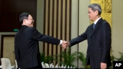 Wang Yu-chi, front left, head of Taiwan's Mainland Affairs Council, shakes hands with Zhang Zhijun, front right, director of China's Taiwan Affairs Office, before their meeting in Nanjing, in eastern China's Jiangsu Province, Feb. 11, 2014. 