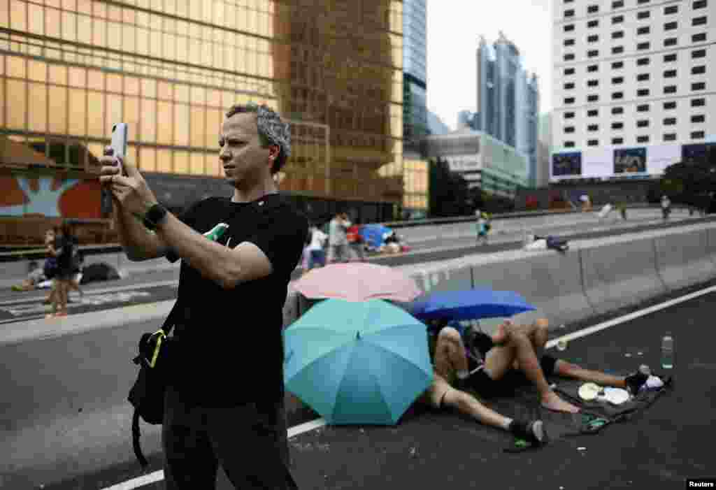 Micha Benoliel, CEO and co-founder of Open Garden, takes a picture on a main road that pro-democracy protesters have blocked at the Central financial district in Hong Kong, Oct. 2, 2014.