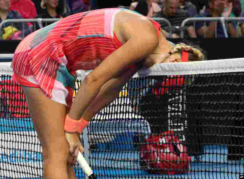 Kristina Mladenovic of France bites the net in frustration after missing a shot against Daria Gavrilova of Australia during their third round match at the Australian Open tennis championships in Melbourne.