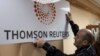 یک مرد در حال نصب تابلوی شرکت تامسون رویترز در یکی از دفاتر بین المللی این خبرگزاری. 