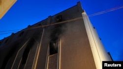 Sebuah gereja Koptik Mesir di Benghazi nampak terbakar (14/3). Gereja ini telah mengalami dua kali serangan dalam seminggu terakhir. (REUTERS/Esam Al-Fetori)