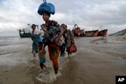 A displaced family arrives after being rescued by a boat from a flooded area of Buzi district, 200 kilometers (120 miles) outside Beira, Mozambique, March 23, 2019.