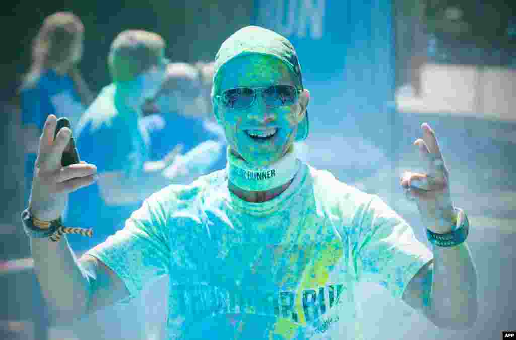 A brightly covered runner smiles during a Color Run in Berlin, Germany.