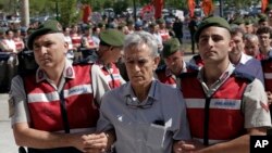 آکین اوزتورک فرمانده پیشین نیروی هوایی و از مظنونان مرتبط با کودتای سال ۱۳۹۵ ترکیه در حال انتقال به دادگاه در آنکارا - ۱۰ مرداد ۱۳۹۶ 