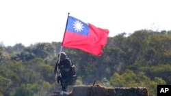 FILE - A soldier holds a Taiwanese flag during a military exercise aimed at repelling an attack from China in Hsinchu County, northern Taiwan, Jan. 19, 2021. 