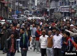 People stand on a road after vacating buildings following an earthquake in Srinagar, October 26, 2015.