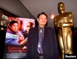 FILE - Director Ang Lee stands next to the movie poster for his Academy Award-nominated film, "Crouching Tiger, Hidden Dragon," at the Academy of Motion Pictures of Arts and Sciences in Beverly Hills, March 23, 2001.