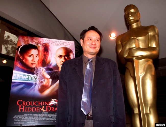 Director Ang Lee stands next to the movie poster for his Academy Award-nominated film, "Crouching Tiger, Hidden Dragon," at the Academy of Motion Pictures of Arts and Sciences in Beverly Hills, March 23, 2001 | voanews.com