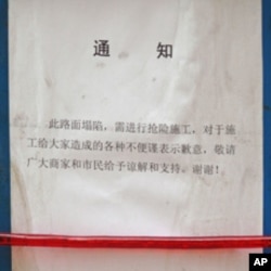 Chinese notice hangs on a metal barrier of the construction site on Wangfujing Street in Beijing.
