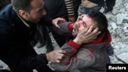 A man reacts after what activists said was an air raid by forces loyal to Syrian President Bashar Al-Assad in Aleppo's al-Marja district, Dec. 23, 2013. 