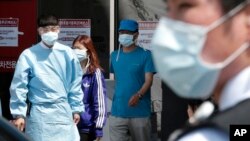 Hospital workers and visitors wearing masks to protect against the MERS, Middle East Respiratory Syndrome, virus at a quarantine tent in Seoul, South Korea June 3, 2015. (AP Photo/Ahn Young-joon)