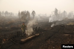 Seorang tentara memeriksa kebakaran lahan gambut dekat Palangkaraya, Kalimantan Tengah, 28 Oktober 2015. (Foto: Antara via Reuters)