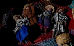 Handmade dolls depicting an Uru family lay on a woven textile in the home of Evarista Flores, in the Urus del Lago Poopo indigenous community, in Punaca, Bolivia, Monday, May 24, 2021.