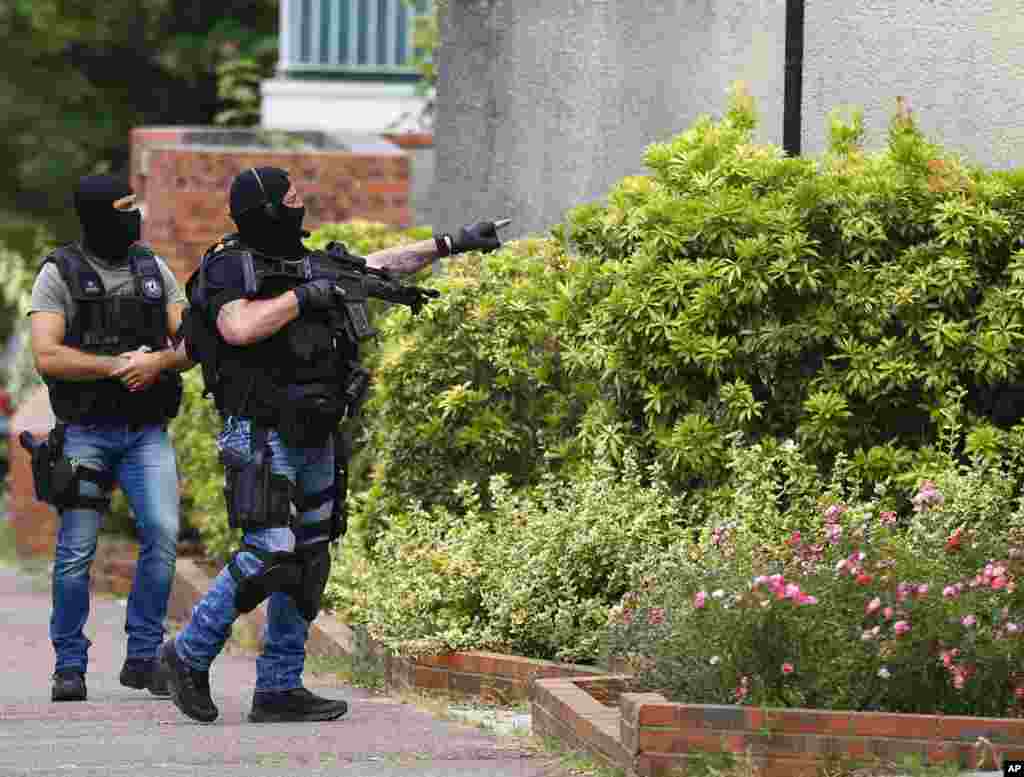 Hooded Police officers conduct a search in Saint-Etienne-du-Rouvray, Normandy, France, following an attack on a church that left a priest dead. Two attackers invaded a church during morning Mass near the Normandy city of Rouen, killing an 84-year-old priest by slitting his throat and taking hostages before being shot and killed by police, French officials said.