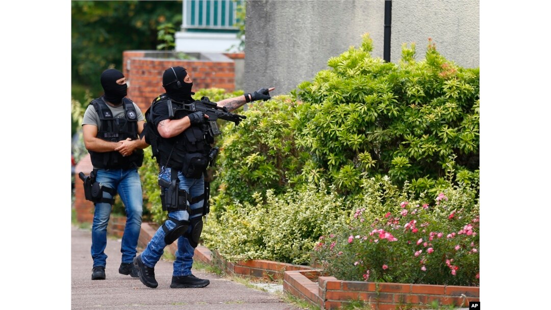 Hooded police officers conduct a search in Saint-Etienne-du-Rouvray, Normandy, France, following an attack on a church that left a priest dead, July 26, 2016.