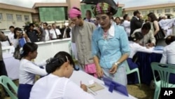 Volunteers in Shan ethnic traditional costume enroll to get ballots in a demonstration on voting for the upcoming general election, in Naypyitaw, Burma's new administrative capital, 18 Oct 2010