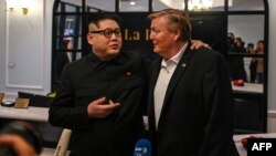 Dua orang yang wajahnya mirip Kim Jong Un dan Donald Trump berbicara kepada media di Hanoi, Vietnam (25/2). Trump-Kim akan mengadakan KTT kedua di Hanoi 27-28 Februari ini. 