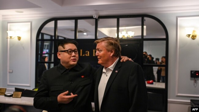 'Kim Jong Un giả', tên thật là Howard X (trái) và 'Donald Trump giả' Russel White nói chuyện với truyền thông tại khách sạn trước khi ông Howard X bị dẫn độ ra phi trường. Ảnh chụp ở Hà Nội ngày 25/2/2019. (Photo by Manan