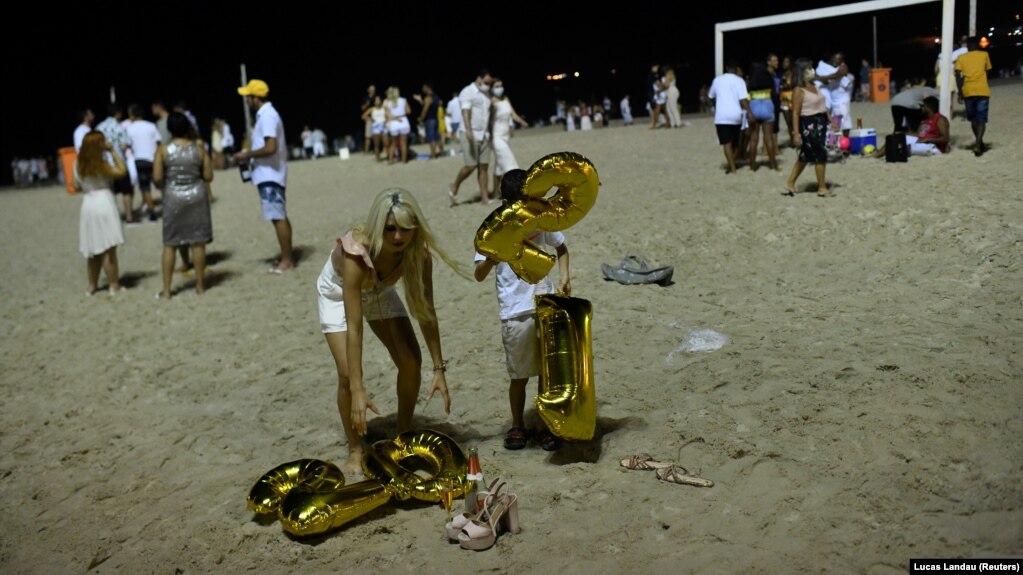 Para pengunjung merayakan malam Tahun Baru di tengah wabah virus corona (COVID-19) di Pantai Copacabana, di Rio de Janeiro, Brazil, 1 Januari 2021. (Foto: Lucas Landau/Reuters)