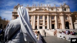 FILE - A nun waits for the arrival of Pope Francis for his weekly general audience, in St. Peter's Square at the Vatican, Sept. 26, 2018.