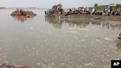 Villagers gather near where a boat capsized as rescuers search in the Yamuna River near Baghpat town in Uttar Pradesh state, India, Sept.14, 2017. A boat crowded with construction workers capsized in the Yamuna River early Thursday and 19 bodies have been