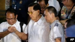 Former Senate President Juan Ponce Enrile, second left, is pictured leaving the Philippine National Police upon his surrender on corruption charges on July 4, 2014, at Camp Crame at suburban Quezon city, northeast of Manila.