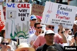 Immigration activists hold signs against family separation during a rally to protest against the Trump Administration's immigration policy, outside the White House in Washington, June 30, 2018.