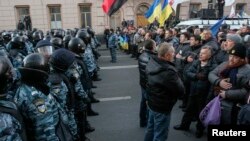 Polisi berjaga di depan para demonstran pendukung integrasi Uni Eropa di depan Gedung Parlemen Ukraina di Kiev (3/12).