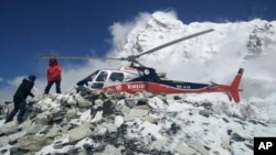 FILE - Helicopter prepares to rescue people at Everest Base Camp, which had been struck by an avalanche triggered by a massive earthquake in Nepal, April 27, 2015.