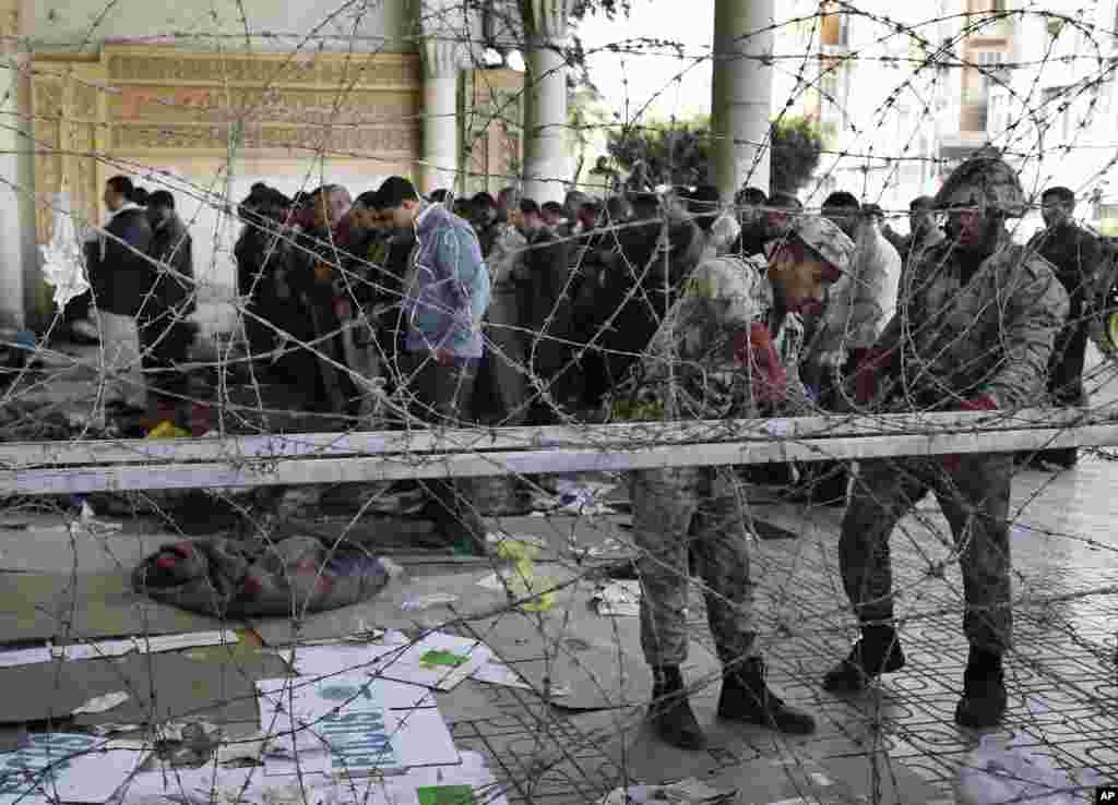 12月6日，埃及总统穆尔西的支持者在总统府附近祈祷时，军队的士兵设置铁丝网