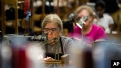 FILE - Workers take part in the manufacturing of Kangol hats the Bollman Hat Company in Adamstown, Pa., May 1, 2017.