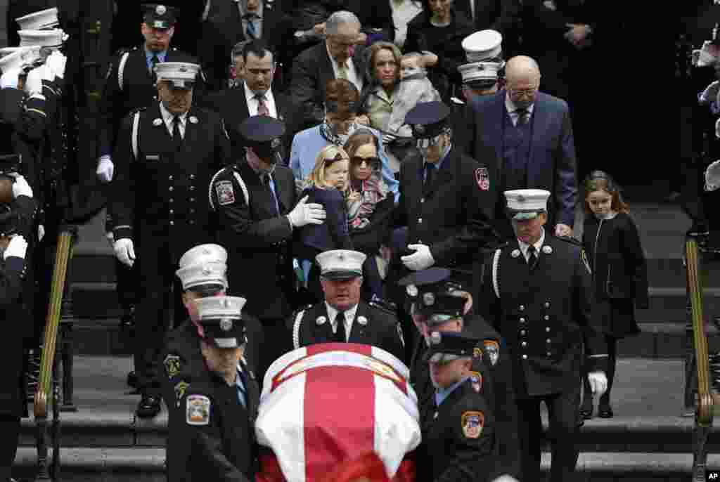 The family of firefighter Michael Davidson, including his wife Eileen Davidson, center, follow the casket out of St. Patrick's Cathedral after his funeral in New York.