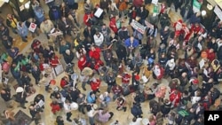 Demonstrators bang drums and chant inside the state Capitol during the eighth day of protesting against Governor Scott Walker's bill to eliminate collective bargaining rights for many state workers, in Madison, Wis., February 22, 2011